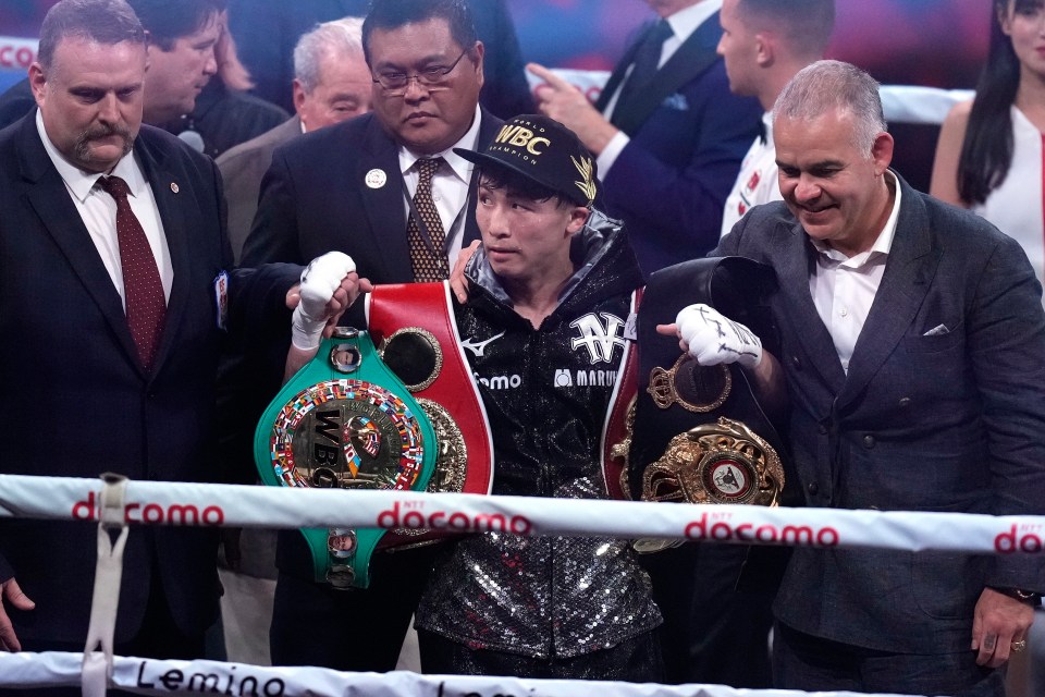 Inoue celebrates with his WBA, WBC, IBF and WBO belts