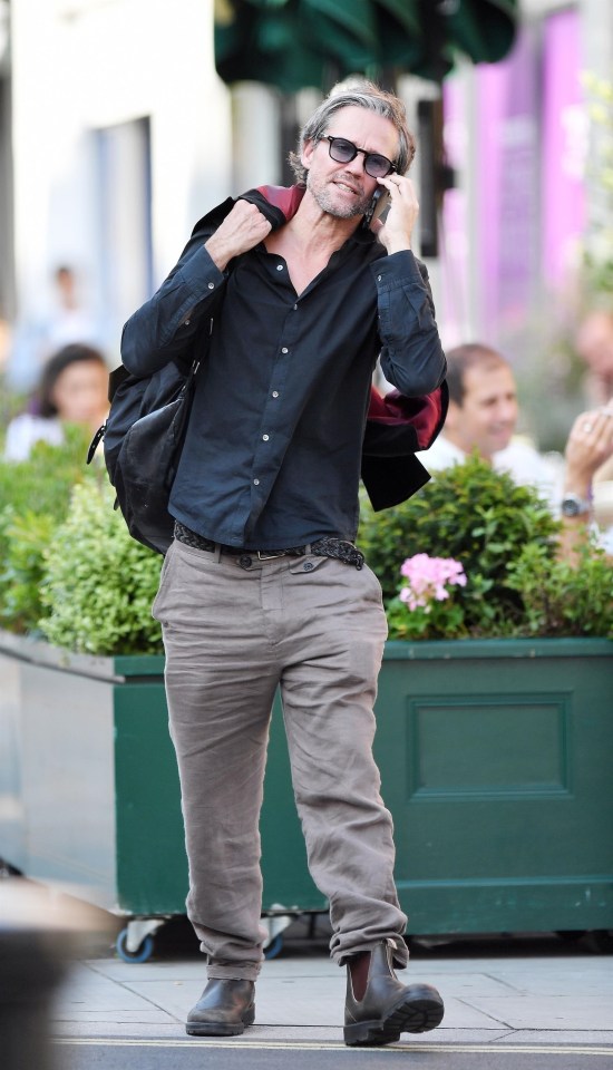 a man talking on a cell phone while carrying a backpack