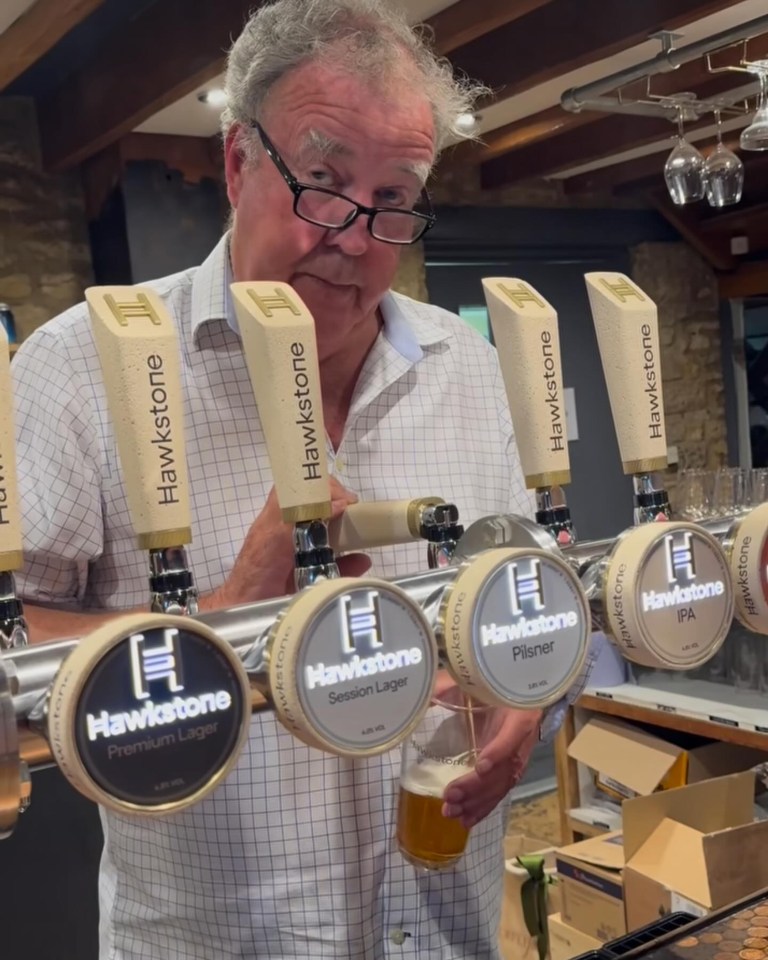 a man stands in front of a hawkstone beer tap