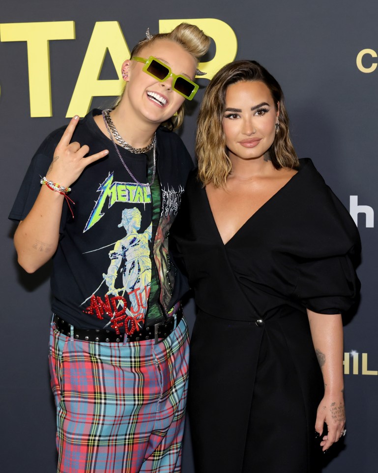 two people posing for a picture with one wearing a metallica shirt