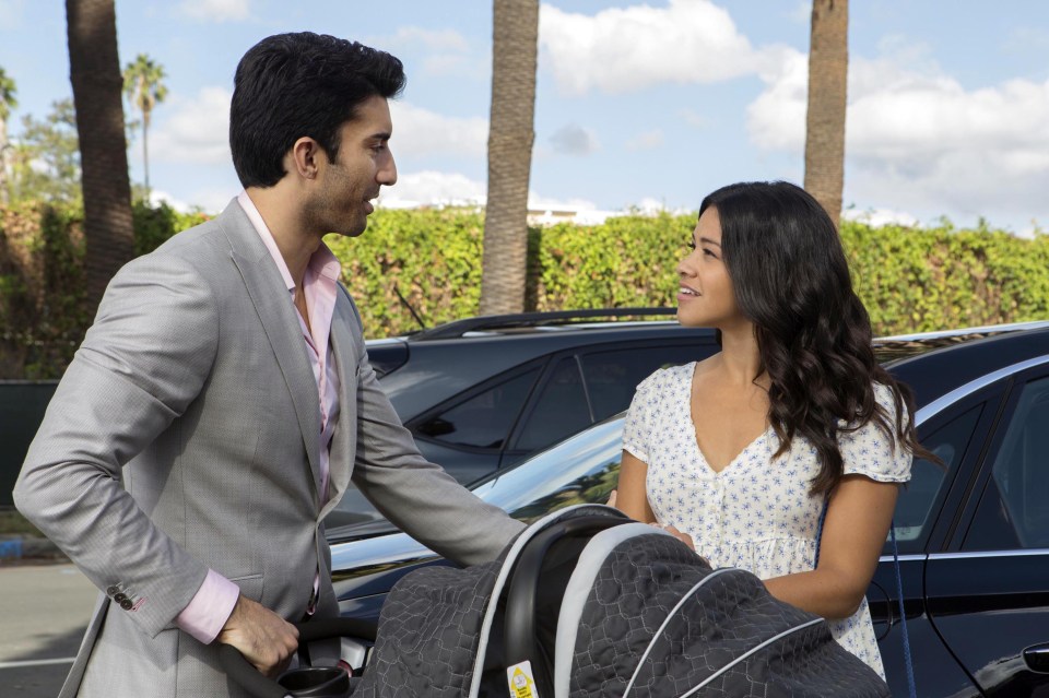 a man and a woman are standing next to a car