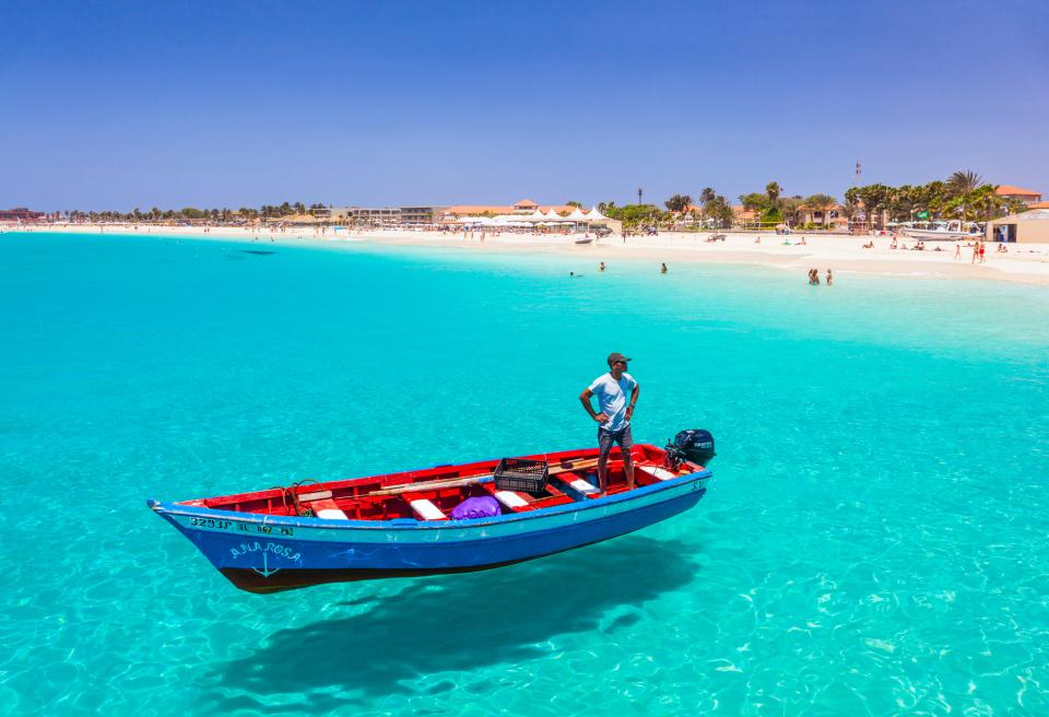 a man in a blue and red boat with the name ana rosa on the side