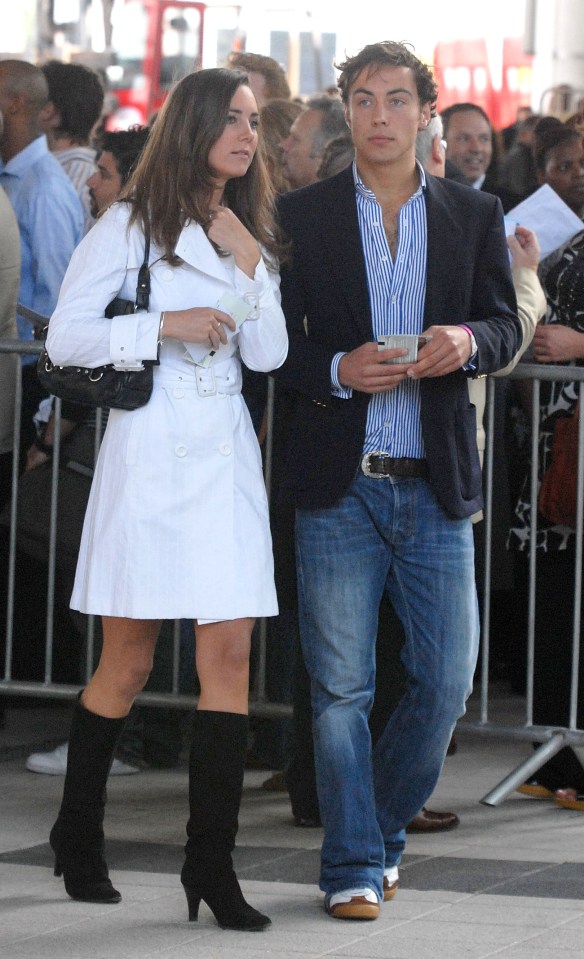 a man and a woman standing next to each other in front of a crowd