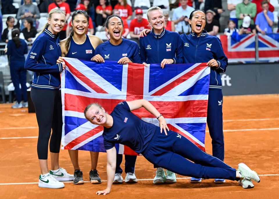 a group of women holding a british flag on a tennis court