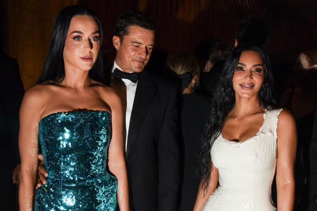 a man in a tuxedo stands next to two women