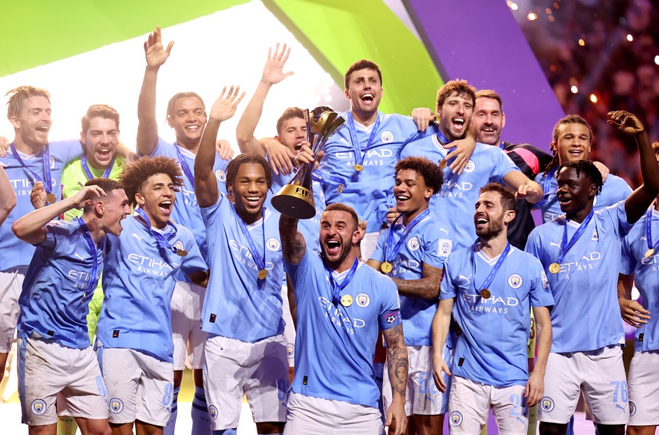 a group of soccer players holding up a trophy that says etihad airways