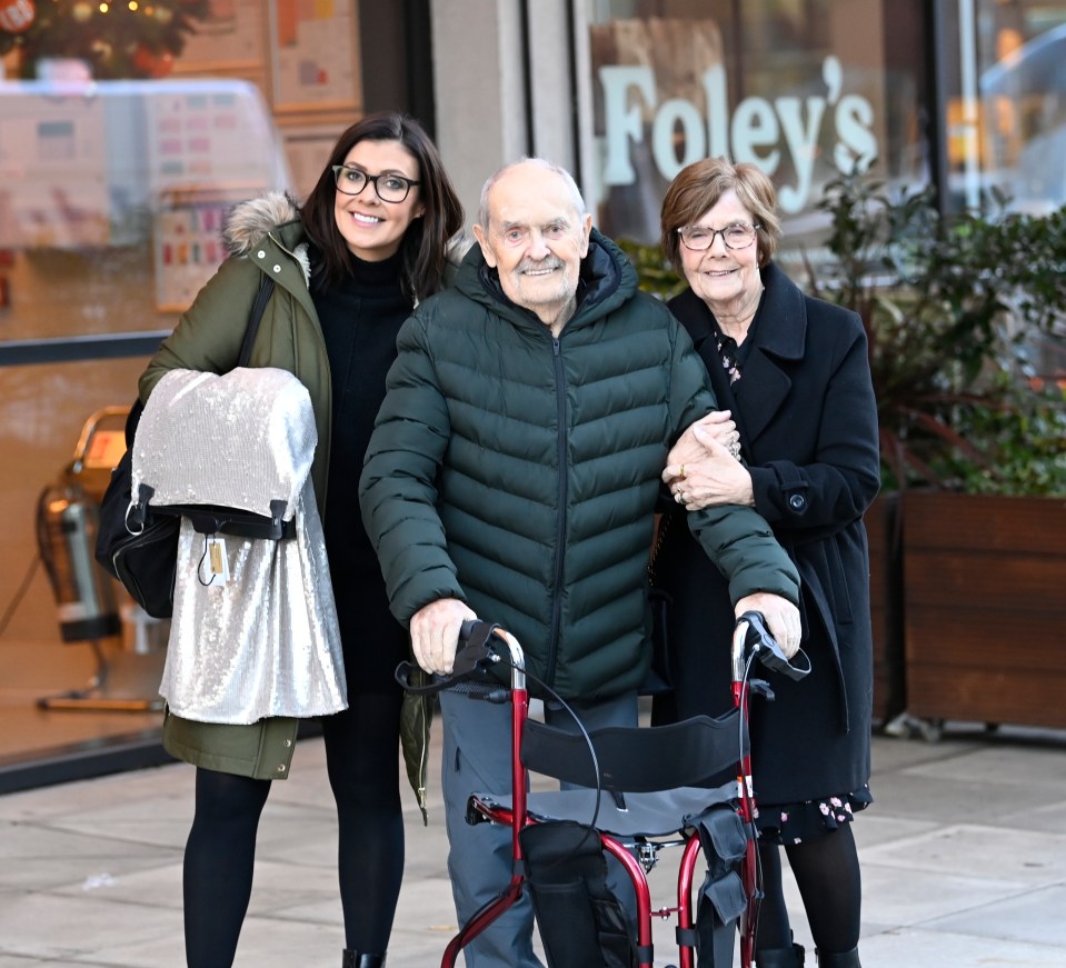 a man with a walker is standing with two women in front of a store called foley 's