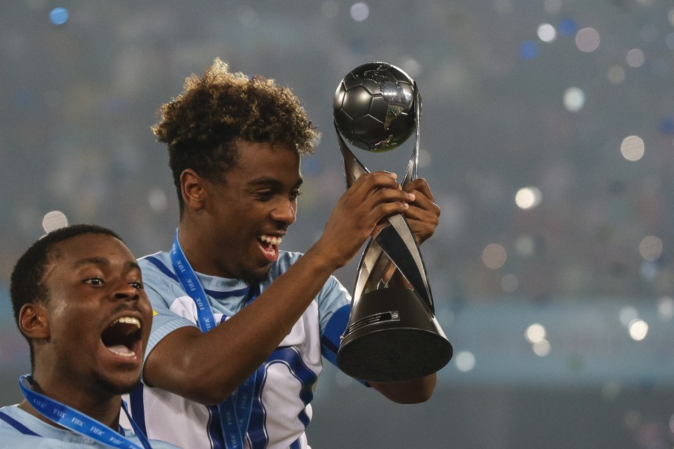 two soccer players holding a trophy that says fifa on it