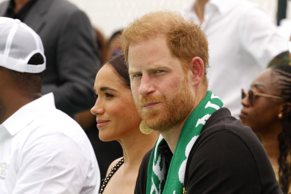 a man with a scarf around his neck that says t on it sits next to a woman