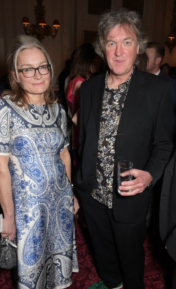 a woman in a blue and white dress stands next to a man in a black suit