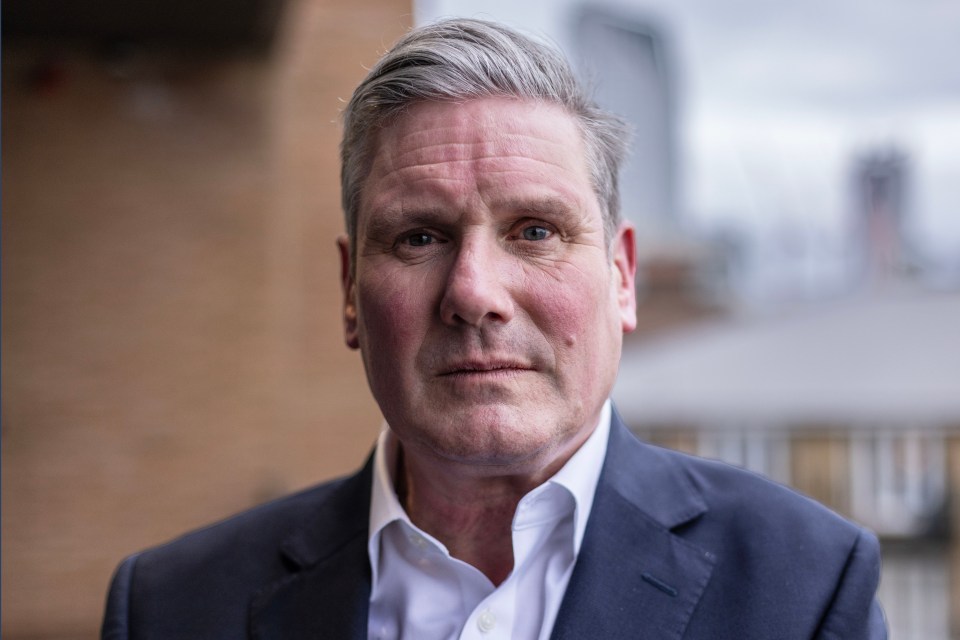 a man in a suit and white shirt looks at the camera