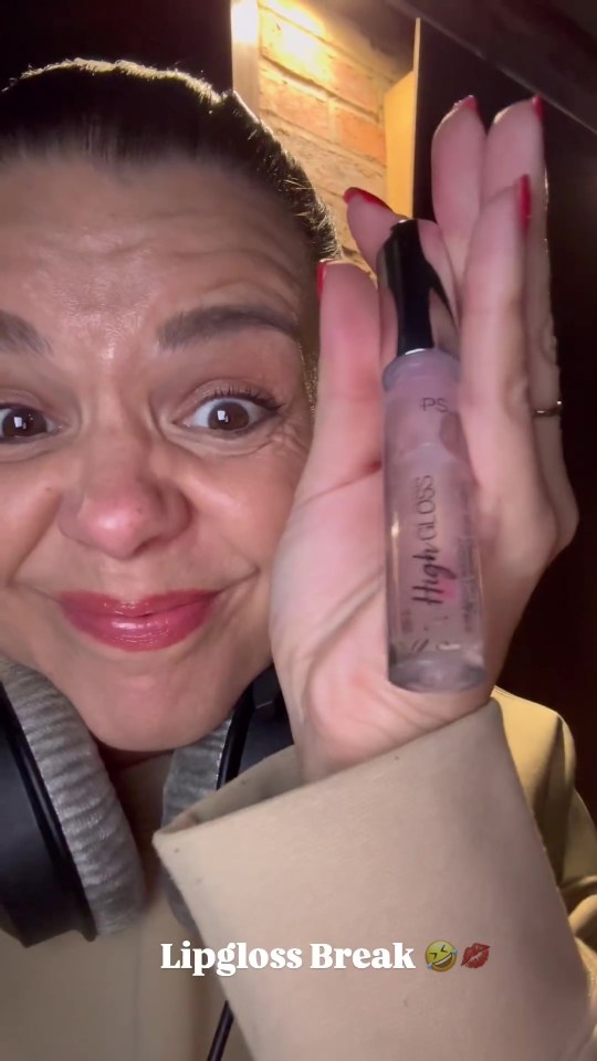 a woman is holding a bottle of lipgloss in her hand