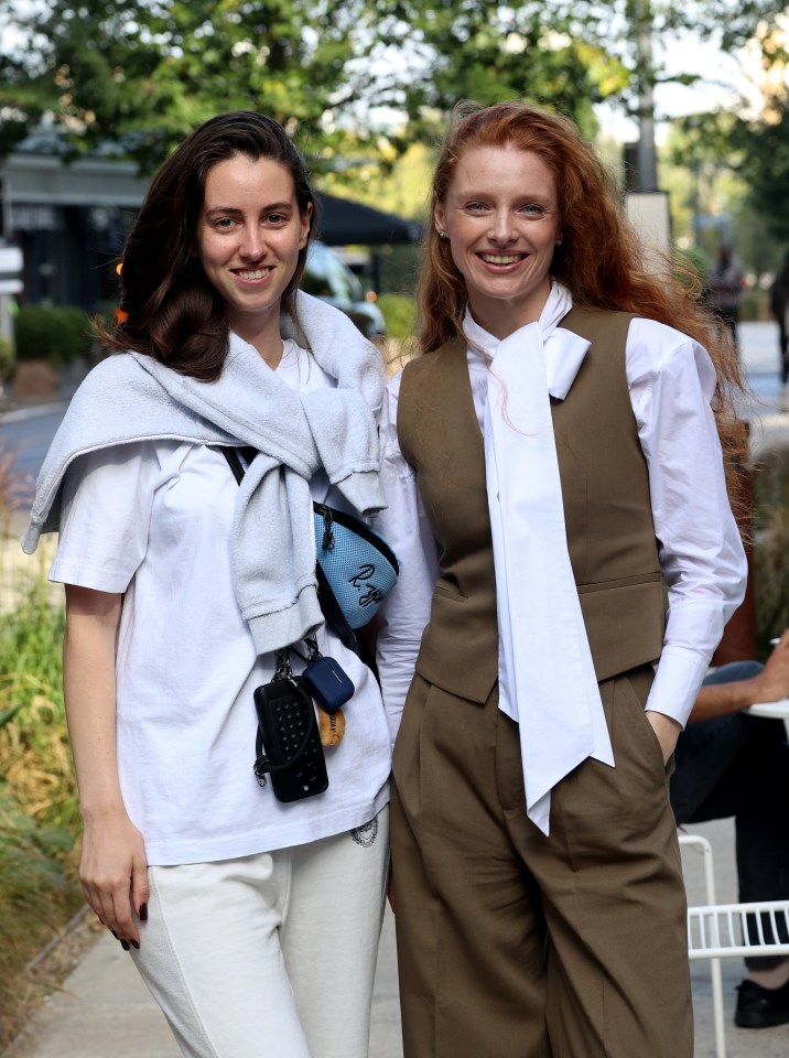 two women posing for a picture with one wearing a white shirt that says ' i love you ' on it