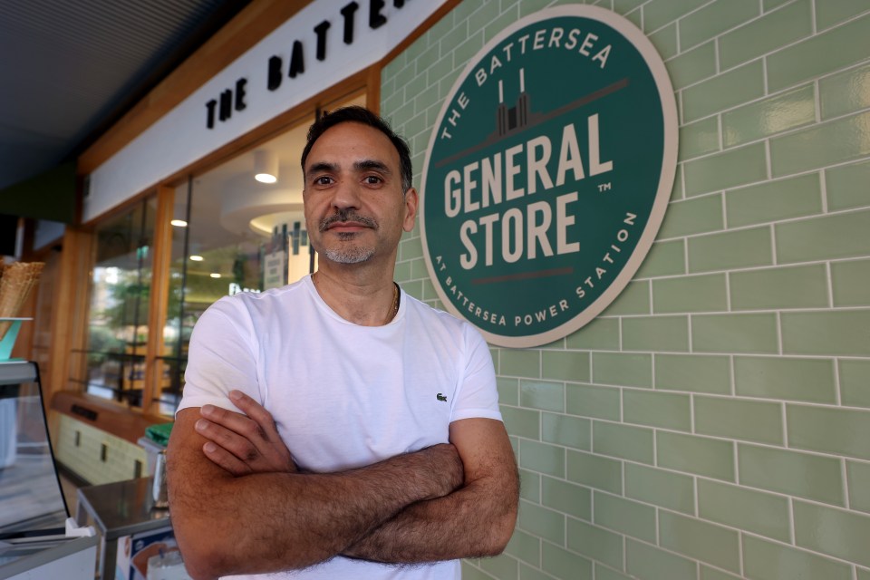 a man stands in front of a sign for the battersea general store