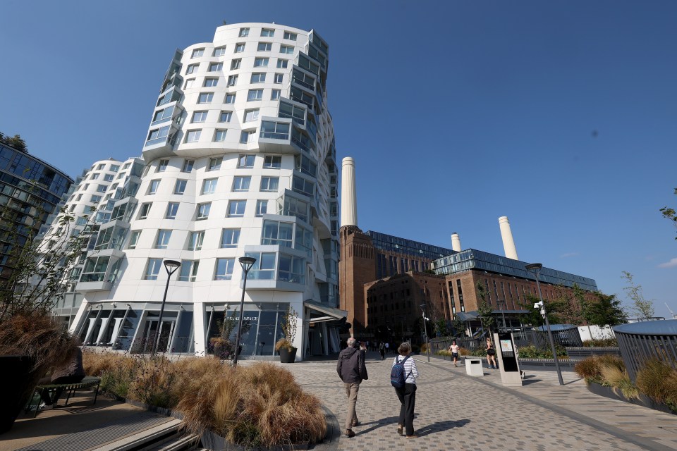 two people walking in front of a building that says ' allianz ' on it