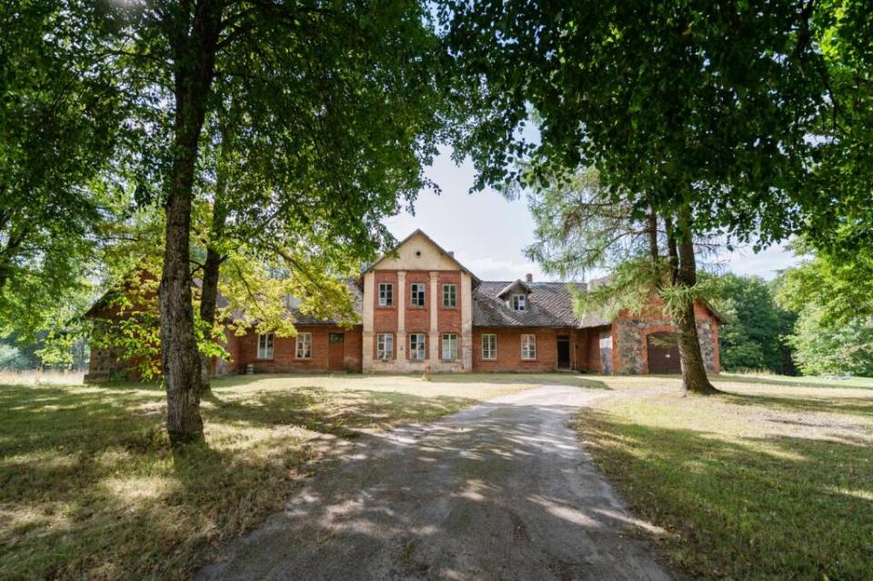 a large brick house is surrounded by trees and grass