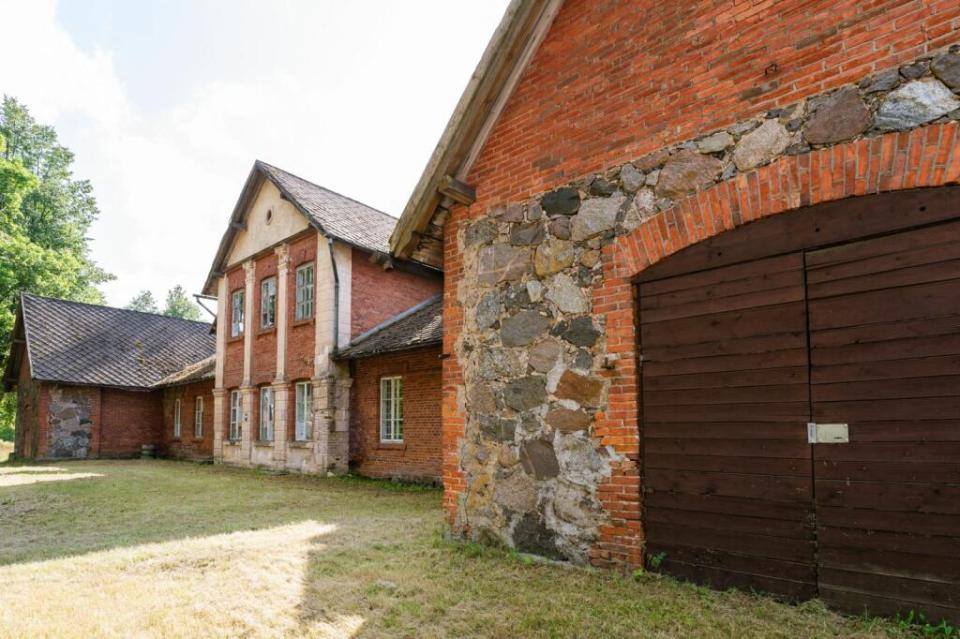 a brick building with a stone wall and a wooden door