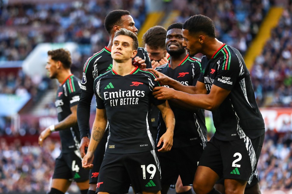 a group of soccer players wearing emirates fly better uniforms