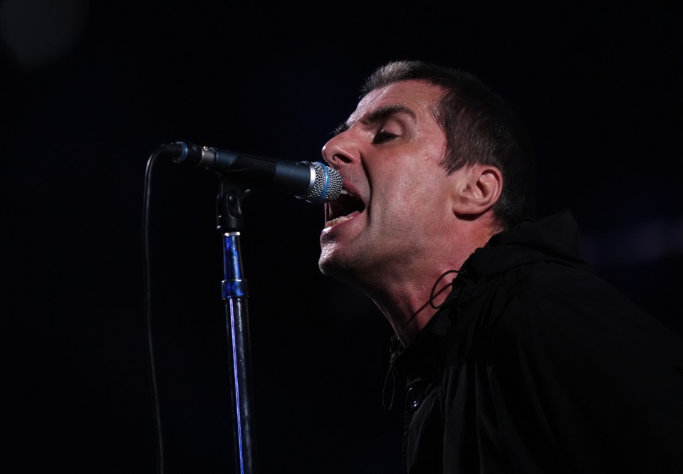 a man singing into a microphone with his mouth open