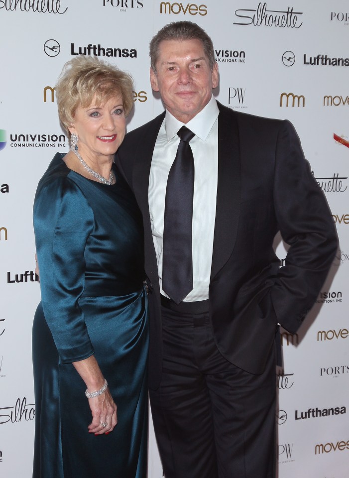 a man and woman pose for a photo in front of a wall that says lufthansa