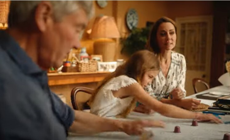 a man and a woman are sitting at a table with a little girl .