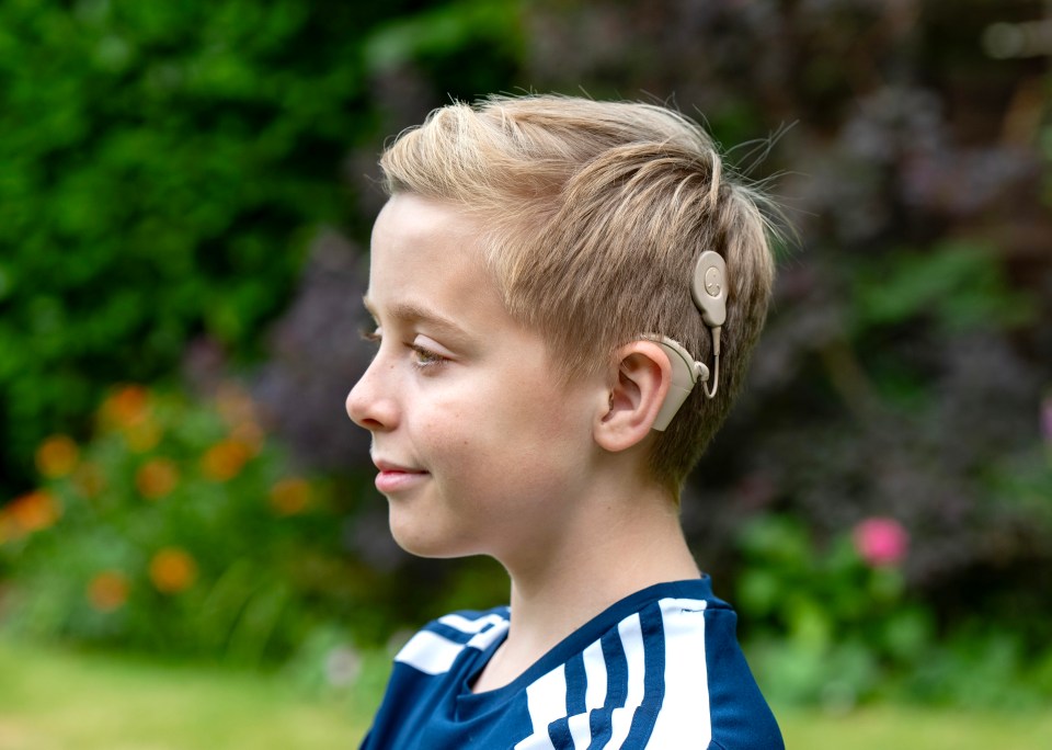 a young boy with a hearing aid on his ear