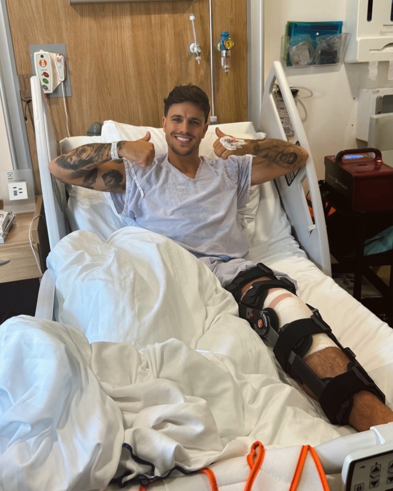 a man in a hospital bed giving a thumbs up