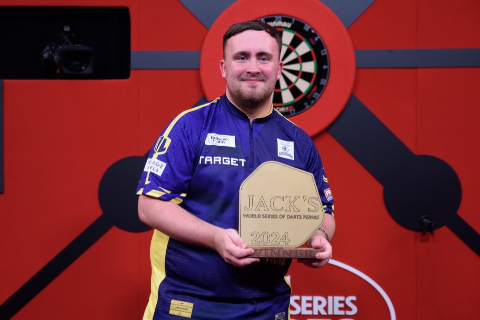 a man holding a plaque that says jack 's world series of darts