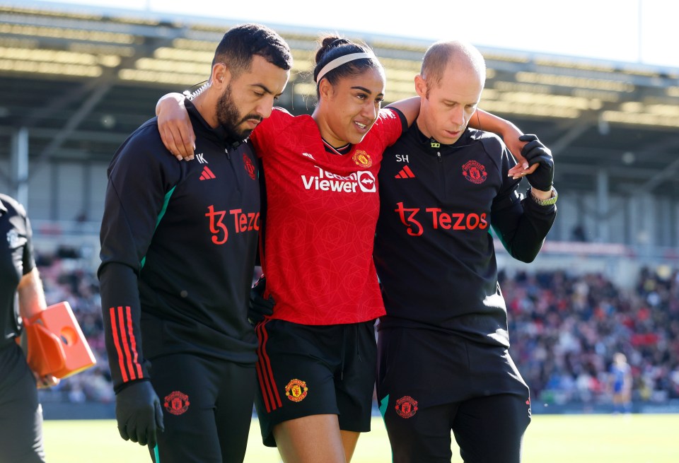 a woman in a red viewer shirt is being helped by two men