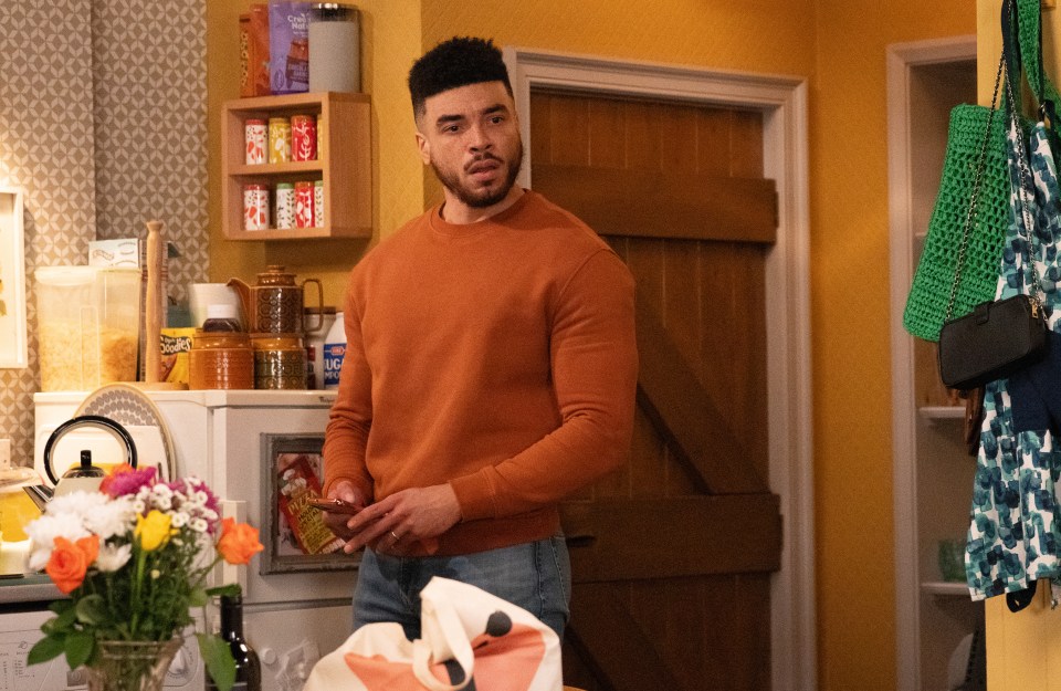 a man in an orange sweater is standing in front of a shelf with a box that says ' oats ' on it