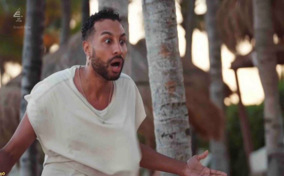 a man in a white shirt is standing in front of palm trees