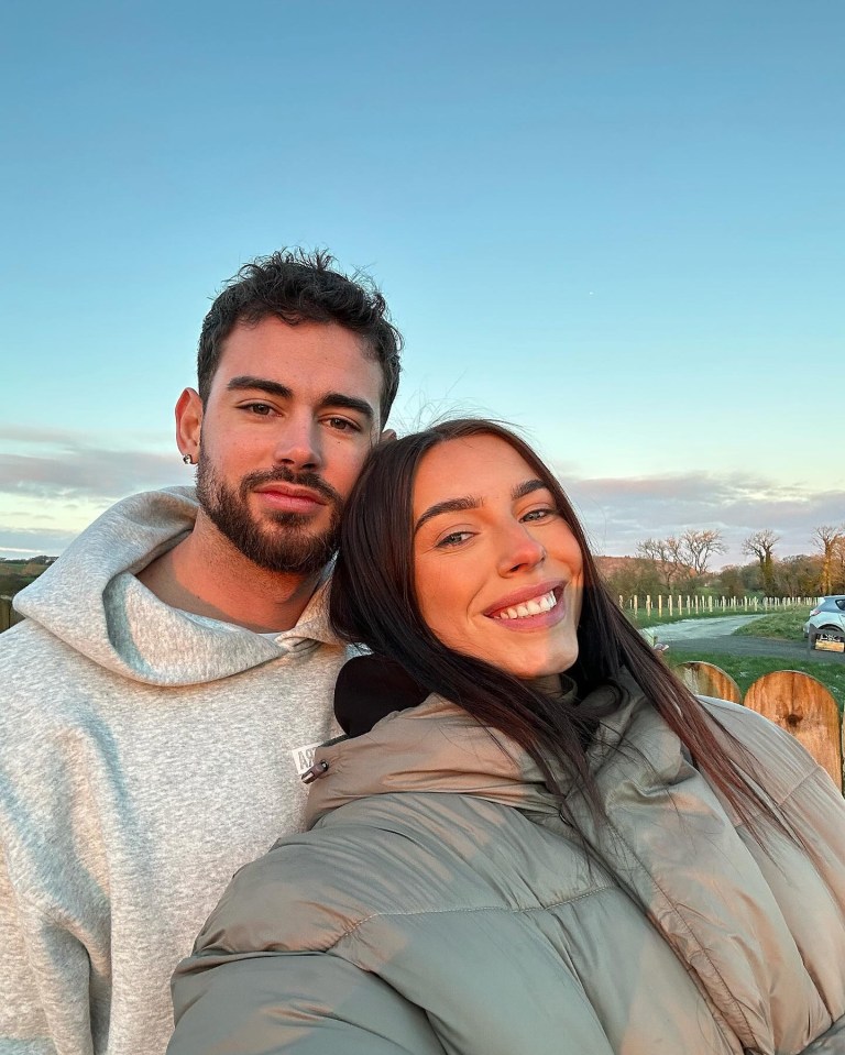 a man and woman pose for a picture with the man wearing a nike hoodie