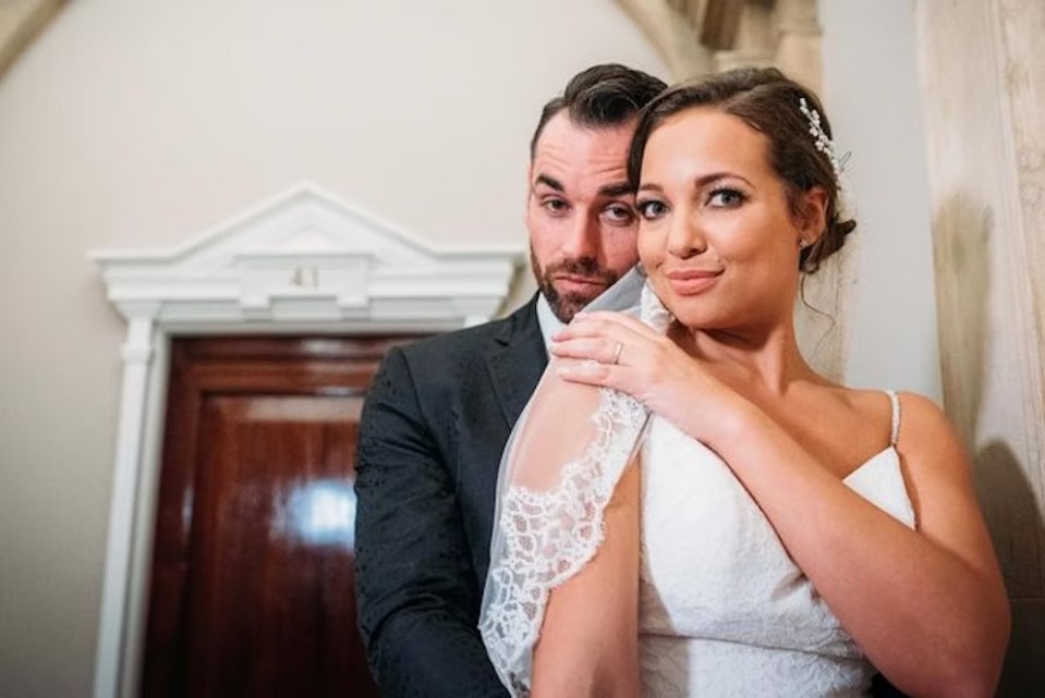 a bride and groom are posing for a picture in front of a door .