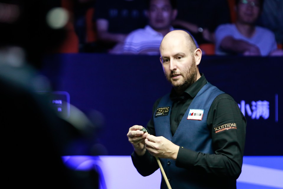 two men are playing snooker in front of a large crowd