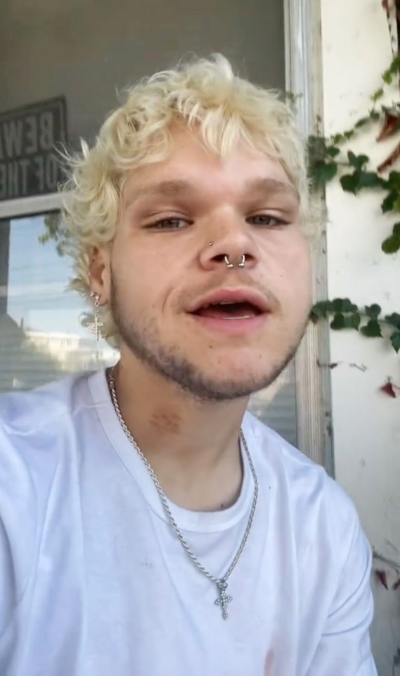 a young man wearing a white shirt and a cross necklace