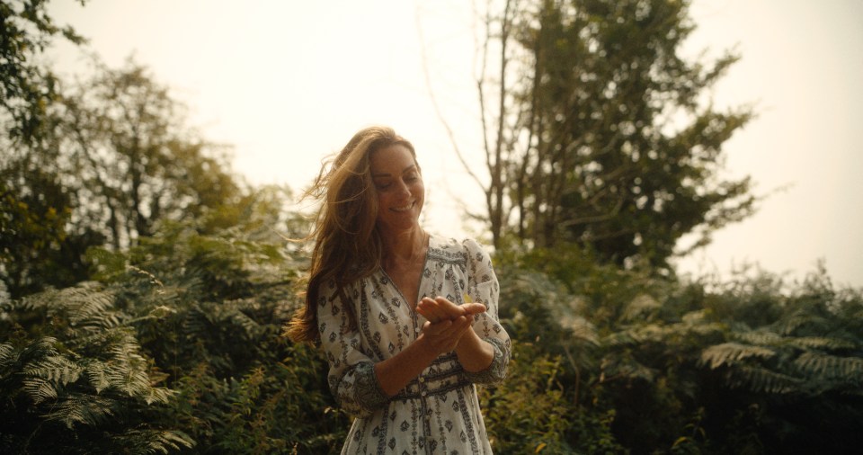 a woman in a white dress is standing in a forest