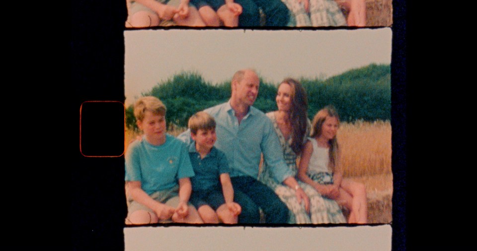 a family sits on a hay bale in a field