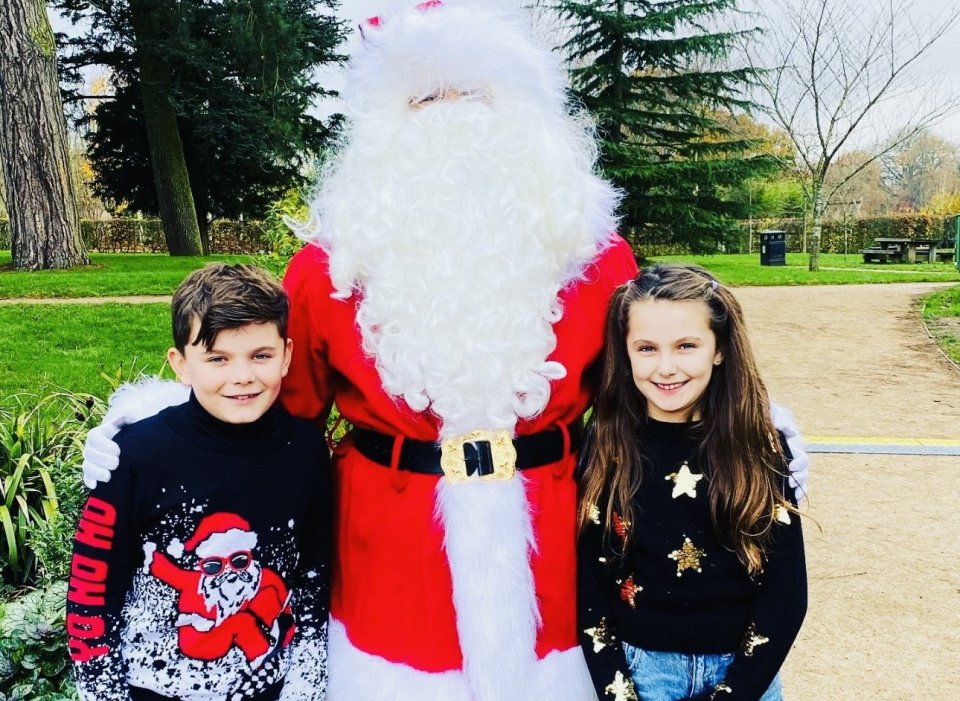 two children are posing for a picture with santa claus