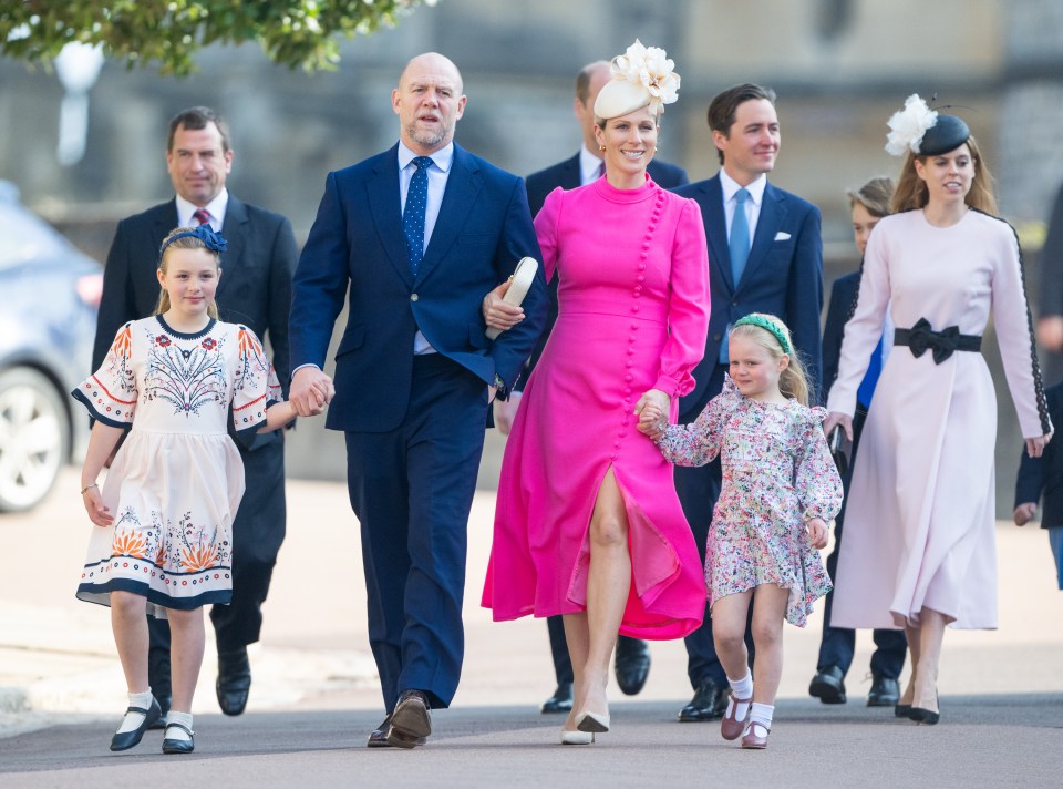 a woman in a pink dress is walking with her family