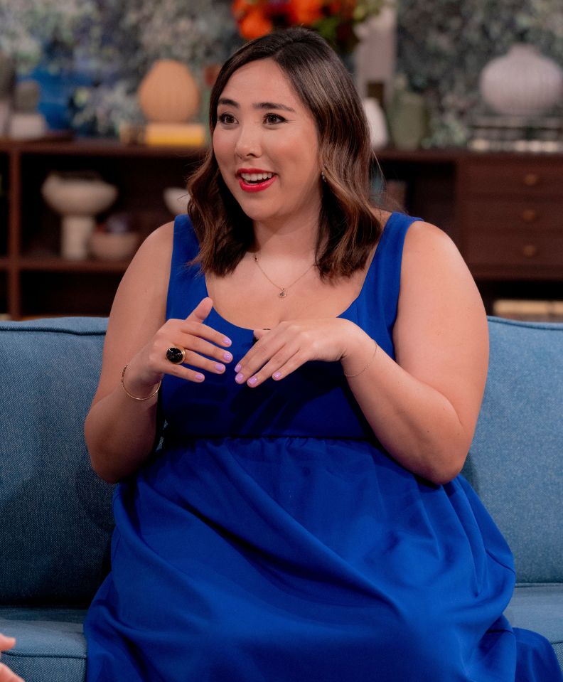 a woman in a blue dress sits on a blue couch