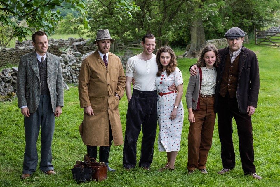 a group of people posing for a picture in a field