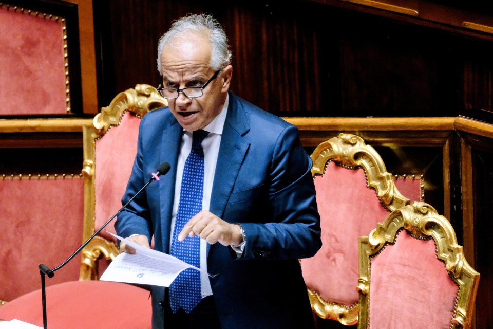 a man in a suit and tie is speaking into a microphone