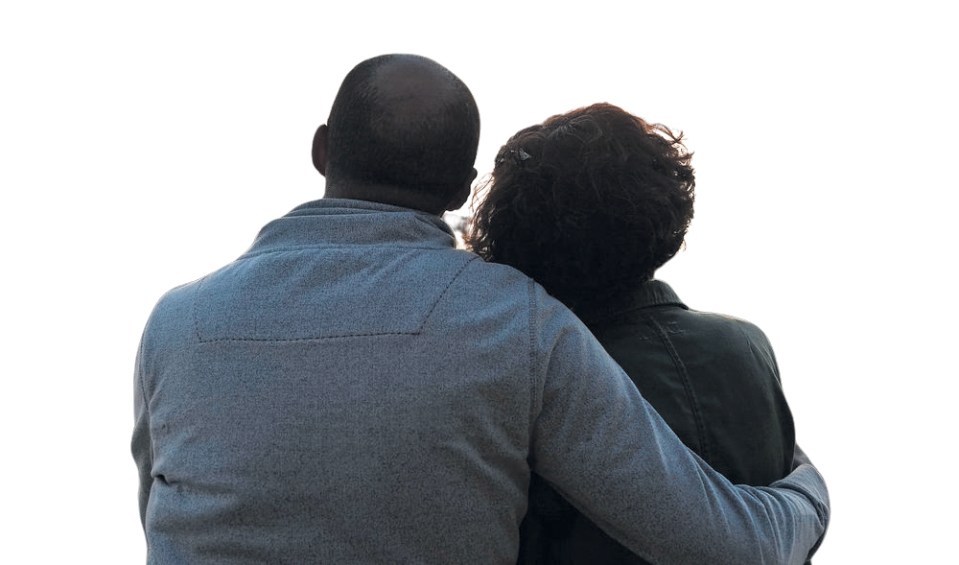 a man and a woman are hugging and looking at something