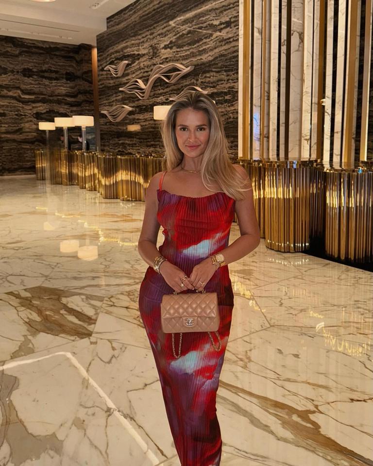 a woman in a red dress holds a chanel purse