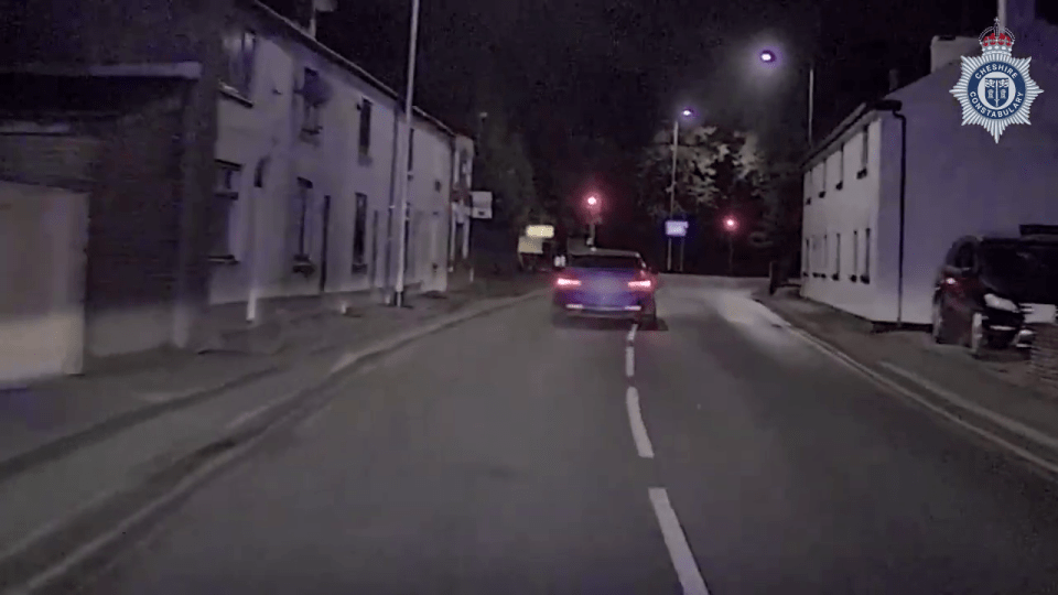 a police car is driving down a street at night