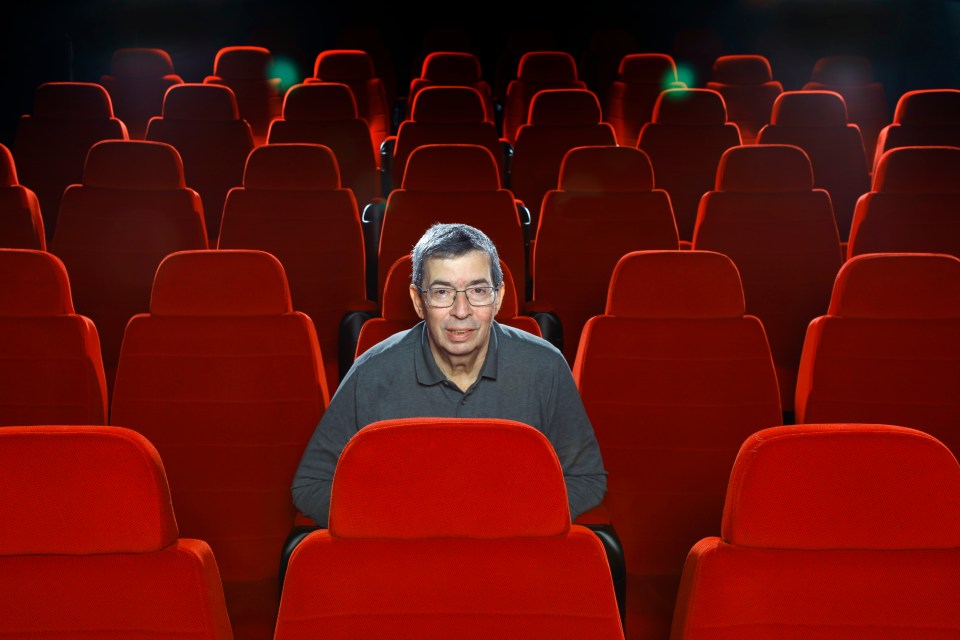 a man sits in an empty theater watching a movie