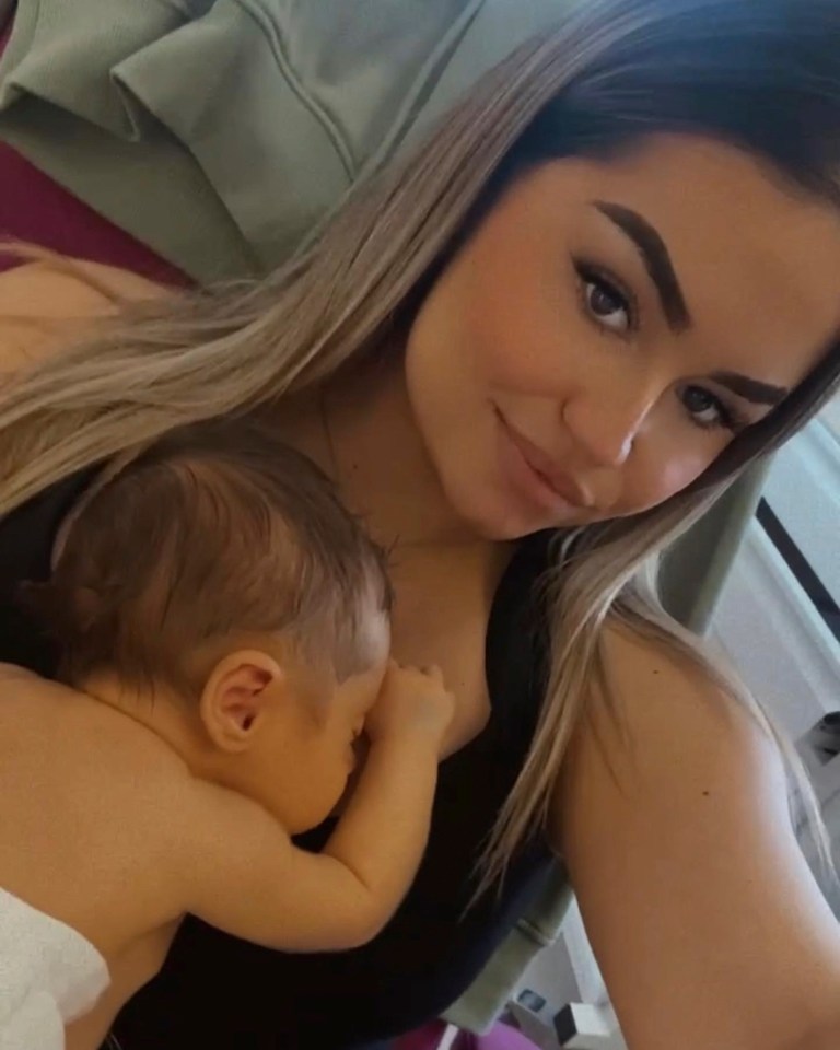 a woman is breastfeeding a baby and taking a selfie