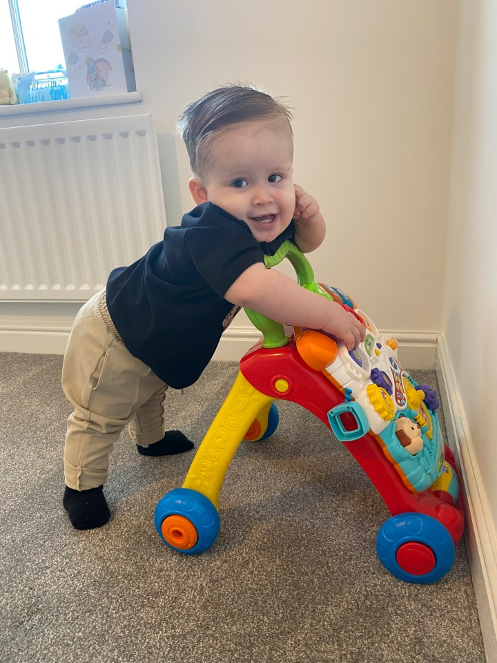 a baby is playing with a toy that says ' walker ' on it