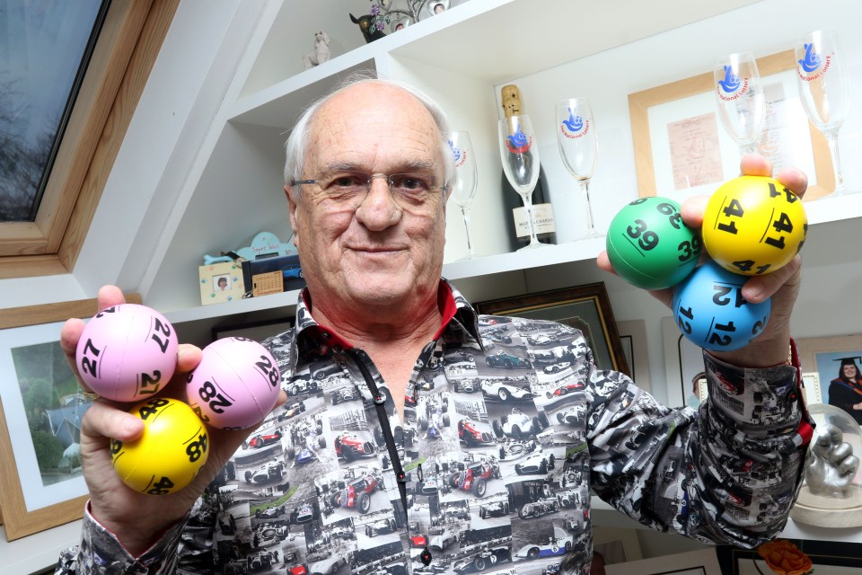 a man in a shirt with cars on it is holding a bunch of lottery balls