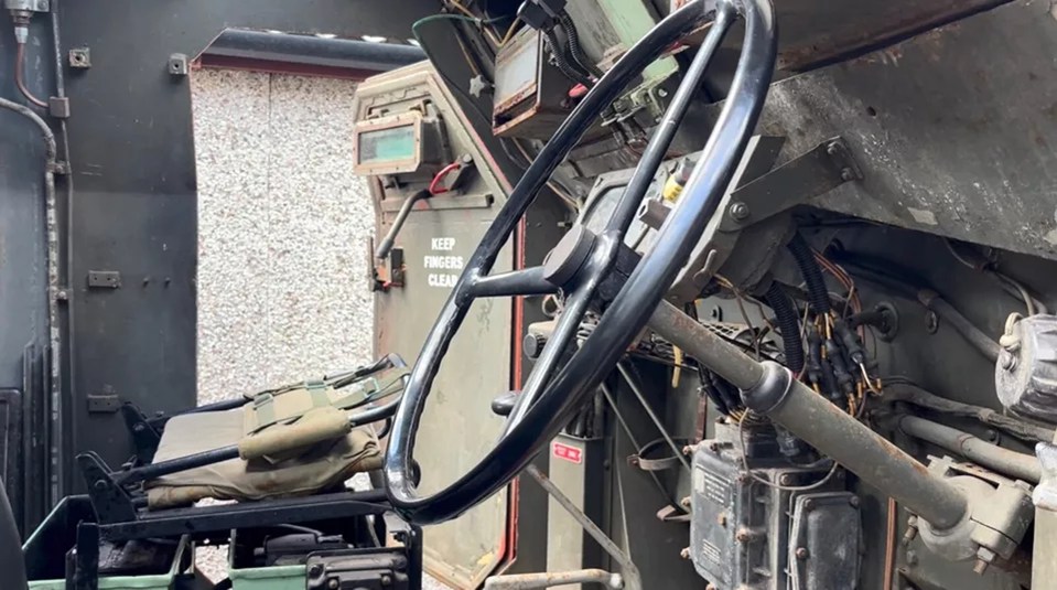 the steering wheel of a military vehicle has a sign on it that says keep fingers clear